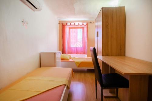 um quarto com 2 camas, uma secretária e uma janela em Hostel Martin em Koper