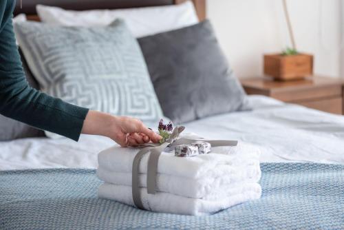 una persona que busca una pila de toallas en una cama en Depto con Vista soñada y tinaja a pasos del centro en Puerto Varas