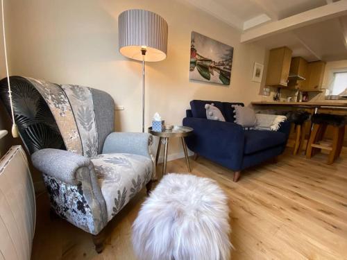 a living room with a couch and a white dog at Fulmar Cottage in Mevagissey