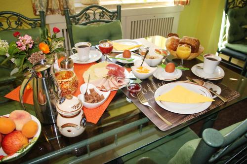 una mesa con comida para el desayuno y bebidas en ella en Pension Villa Irene, en Kurort Gohrisch