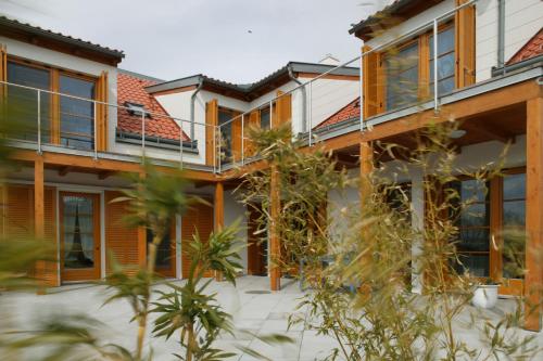 an external view of a house with plants at SCHEIBER Wein & Gästehaus in Weiden am See