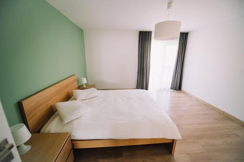 een slaapkamer met een groot wit bed in een kamer bij Penthouse DH Apartments in Oradea