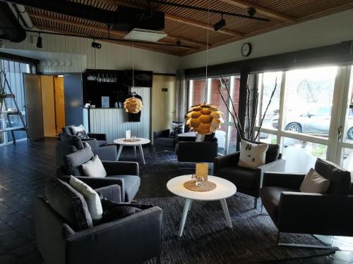 a living room with couches and tables and windows at Máttaráhkká Northern Light Lodge in Kiruna