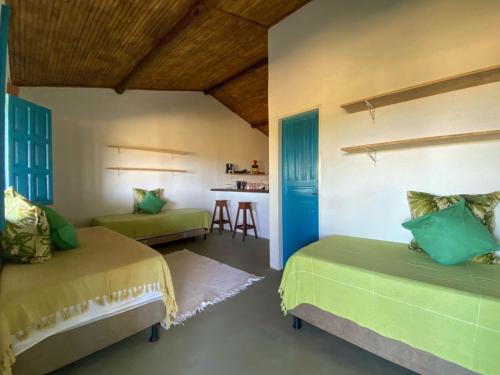 ein Schlafzimmer mit 2 Betten und eine Küche mit einem Tisch in der Unterkunft OCA Caraíva in Caraíva
