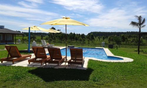 a group of chairs and umbrellas next to a pool at La Celmira in Concordia