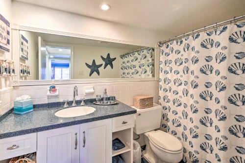 a bathroom with a sink and a toilet and a mirror at Condo with Pool Access Walk to Shopping and Beach! in Naples