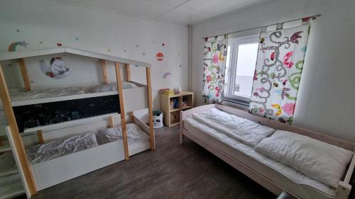 a bedroom with two bunk beds and a window at Nordseeblick 1 - XXL Ferienwohnung in Carolinensiel