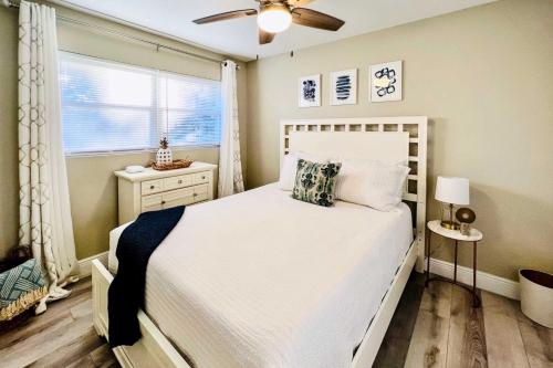 a bedroom with a white bed and a window at Cozy Sarasota Retreat - 3 Blocks to the Coast! in Sarasota