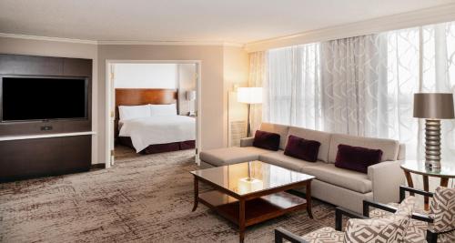 sala de estar con sofá y cama en Chicago Marriott Suites Deerfield, en Deerfield