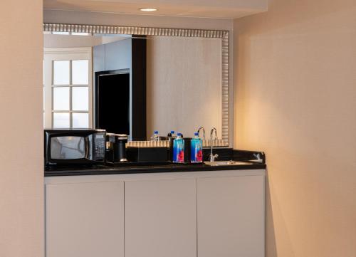 uma cozinha com um micro-ondas e um espelho em Chicago Marriott Suites Deerfield em Deerfield