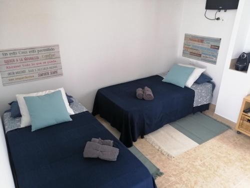 duas camas num pequeno quarto com sapatos em La Mongeta Màgica. em Castellón de la Plana