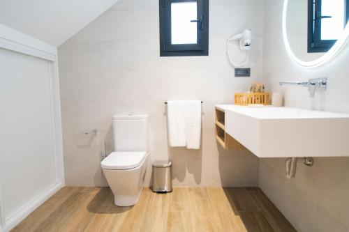 a bathroom with a white toilet and a sink at Laguna Home & Suites in La Laguna