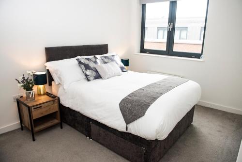 Un dormitorio con una cama grande y una ventana en Chi-Amore- 1 bed apartment-Bedford Town (Free Gym), en Bedford