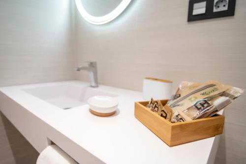 a bathroom counter with a sink and a toilet at Laguna Home & Suites in La Laguna