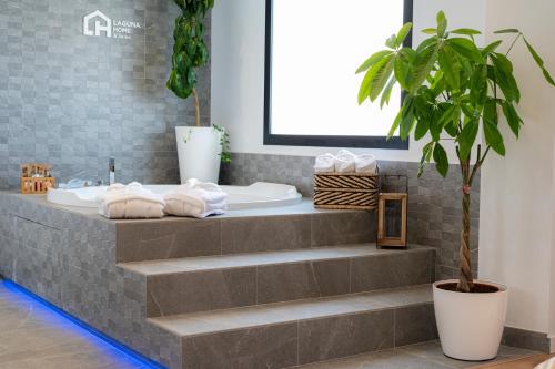 a bathroom with a tub and a potted plant at Laguna Home & Suites in La Laguna