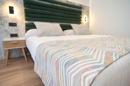 a bedroom with a large bed with a colorful blanket at Laguna Home & Suites in La Laguna