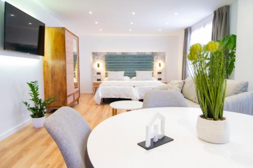 サン・クリストバル・デ・ラ・ラグーナにあるLaguna Home & Suitesのベッド2台、テーブルと椅子が備わるホテルルームです。