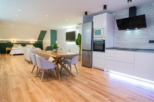 kuchnia i jadalnia z drewnianym stołem i krzesłami w obiekcie Laguna Home & Suites w mieście La Laguna
