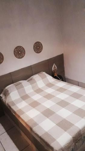 a bed in a room with a checkered blanket on it at Recanto do Sossego Tavares in Baía da Traição