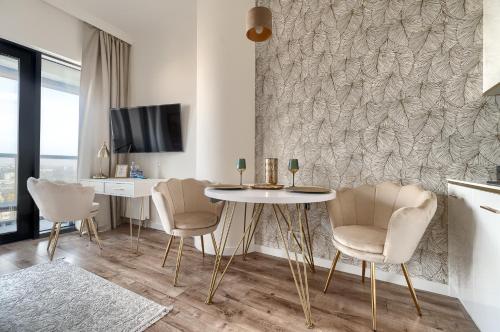 a dining room with a table and chairs at Apartament Hanza Tower 1412 in Szczecin