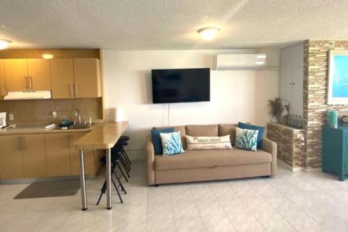 a living room with a couch and a kitchen at KASA Emmas Ocean View in San Juan