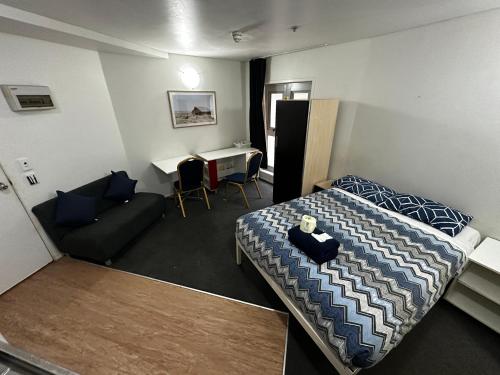 Habitación con cama, sofá y mesa. en Columbia Apartments, en Auckland