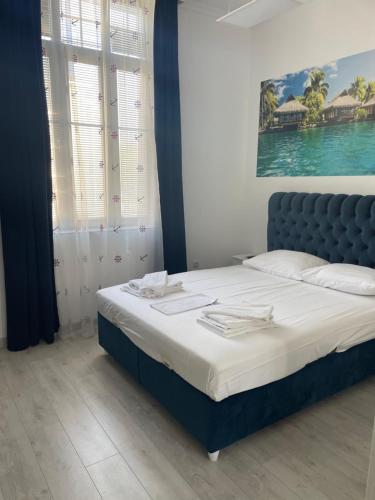 a bedroom with a bed with a blue headboard at Seaman's house in Burgas