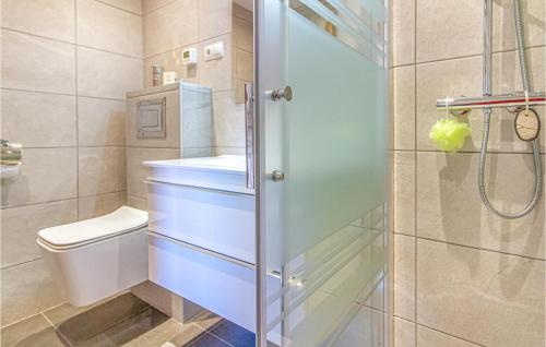 a bathroom with a toilet and a glass shower door at Cozy Apartment In Alhama De Murcia With Wifi in Alhama de Murcia