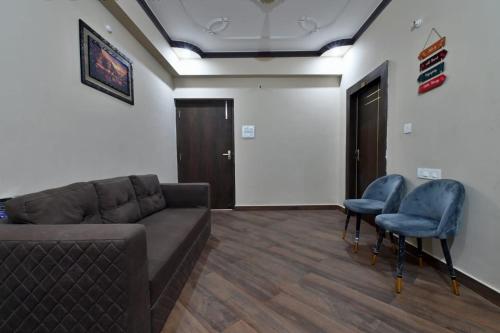 a living room with a couch and two chairs at Hotel Lilac Doors in Patna