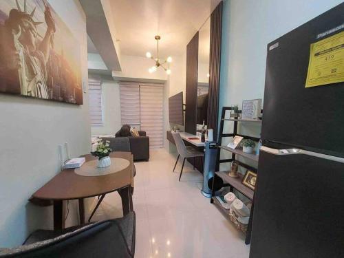 a living room with a table and a refrigerator at MOA Pasay, Shore 3 Residences - Modern Luxury Condo in Manila