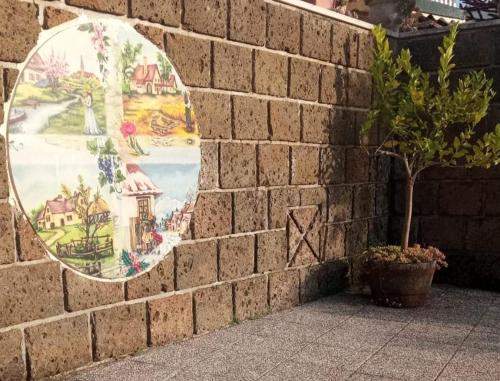 a painting on a brick wall with a potted plant at La Casa Sull'aia,AV in Santo Stefano del Sole