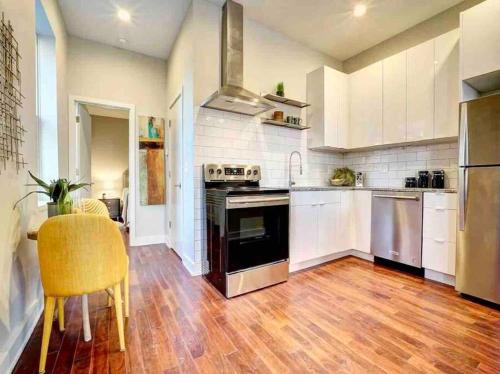 a kitchen with white cabinets and a wooden floor at CUTE & COZY/TQL stadium/ Findlay Market/Brewery in Cincinnati