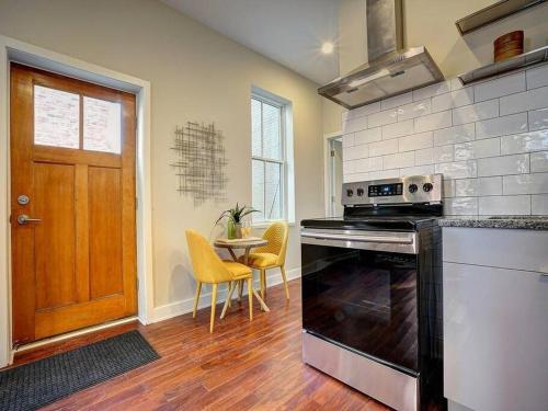 a kitchen with a stove and a table with yellow chairs at CUTE & COZY/TQL stadium/ Findlay Market/Brewery in Cincinnati