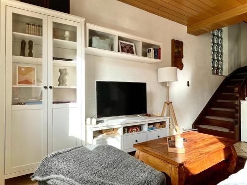 ein Wohnzimmer mit einem TV auf einem weißen Schrank in der Unterkunft Ferienhaus mit Zirbitzblick in Mönchegg