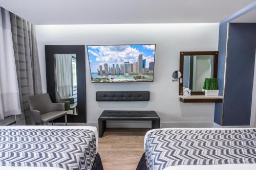 a hotel room with two beds and a chair at Kent Hotel in Miami Beach