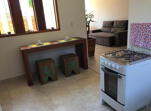 a kitchen with a stove and a living room at Sobrado Torre in Tiradentes
