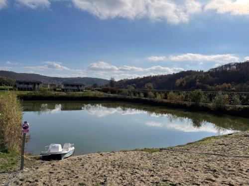 a boat sitting on the water in a river at Domki Nad Sanem Bachórzec 6a in Dubiecko