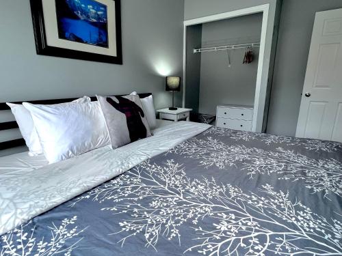 a bedroom with a bed with a blue and white bedspread at Canadian Rockies Chalets by Trilink - 2 & 3 Bedroom Condos - Self Check-In - Walking Distance to Downtown - Free Parking - Pet-Friendly - No AC in Canmore