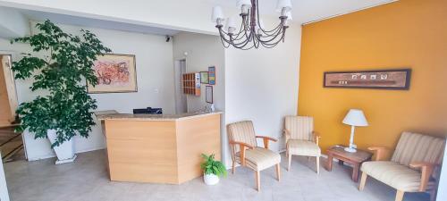 una sala de espera con sillas y un mostrador en una habitación en hotel py jaguarão en Jaguarão
