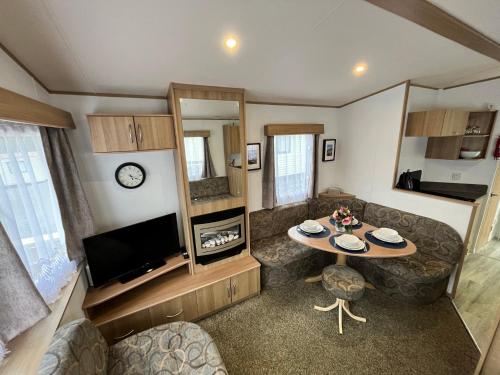 a small living room with a table and a tv at JS Holidays Tebay Lagganhouse in Ballantrae