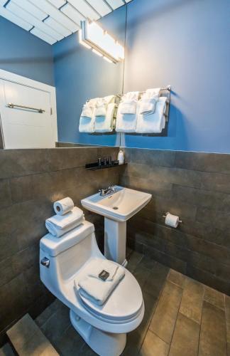 a bathroom with a toilet and a sink and a mirror at Kent Hotel in Miami Beach