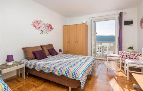 a bedroom with a large bed and a balcony at Gorgeous Apartment In Stara Novalja With Kitchenette in Stara Novalja