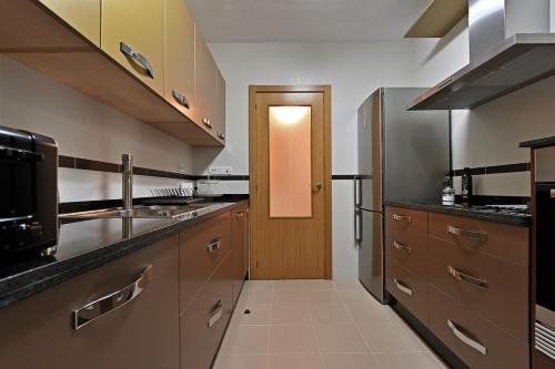 a kitchen with stainless steel appliances and a doorway at Alojamiento Alcantara in Alora