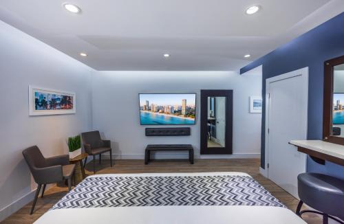 a bedroom with a bed and a tv on the wall at Kent Hotel in Miami Beach
