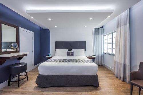 a bedroom with a large bed and a desk at Kent Hotel in Miami Beach
