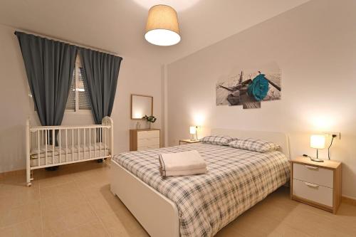 a bedroom with a bed and a crib in it at Alojamiento Alcantara in Alora