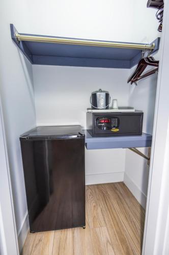 a small kitchen with a microwave on a shelf at Kent Hotel in Miami Beach