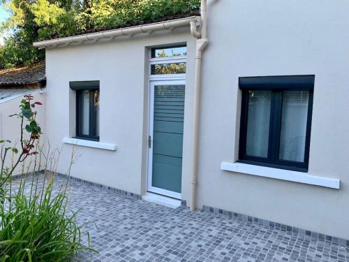 une maison avec une porte bleue et deux fenêtres dans l'établissement Studio Cocooning à 15 mn de Paris et à 8 mn du RER A !, à Sartrouville