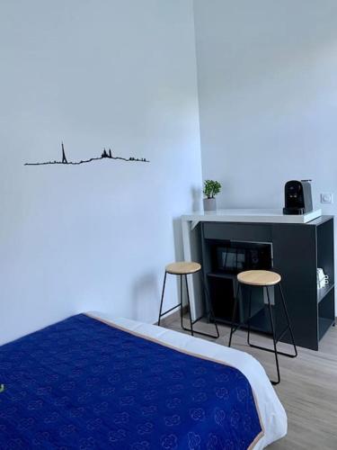 - une chambre avec un lit, deux tabourets et un bureau dans l'établissement Studio Cocooning à 15 mn de Paris et à 8 mn du RER A !, à Sartrouville