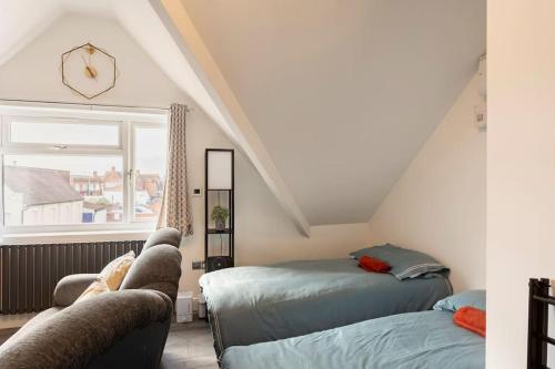 a attic room with two beds and a window at Cosy Brand new spacious 1 bed luxury apartment in Birmingham